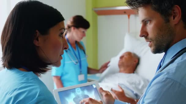 Médecins discutant de rayons X sur tablette — Video