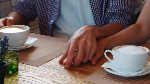 Paar hand in hand terwijl het hebben van cappuccino — Stockvideo