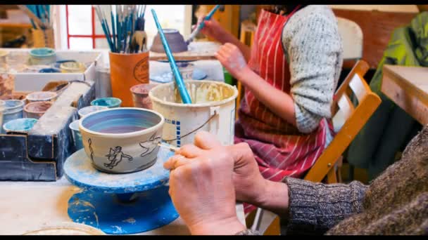 Художники рисуют на глиняной чаше — стоковое видео