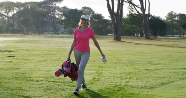 Golfista feminina caminhando com saco de golfe — Vídeo de Stock