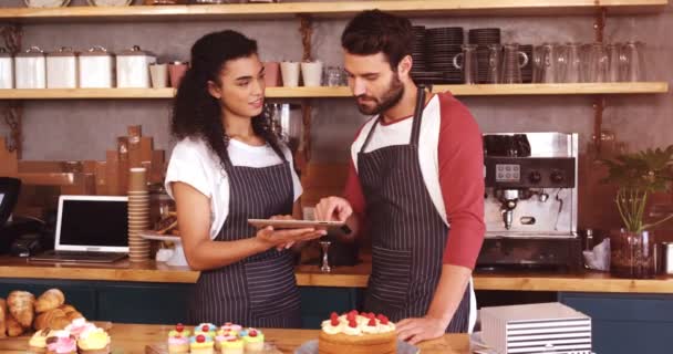 Σερβιτόρος και σερβιτόρα χρησιμοποιώντας tablet στο γκισέ — Αρχείο Βίντεο