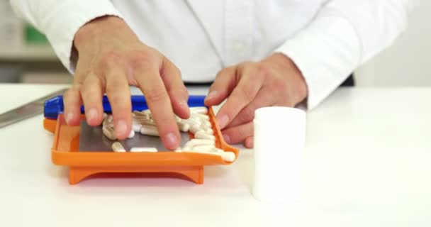 Farmacéutico poner píldora en el envase en la farmacia — Vídeos de Stock