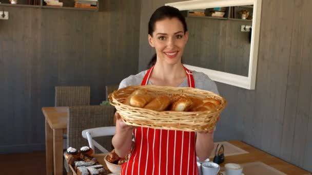 Panadero hembra sosteniendo baguettes en cesta — Vídeo de stock