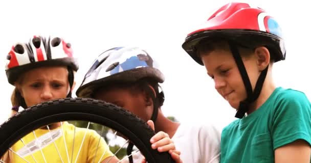 Группа детей смотрит на велосипедное колесо — стоковое видео