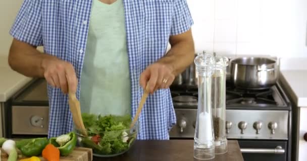 Homem misturando uma salada na cozinha — Vídeo de Stock