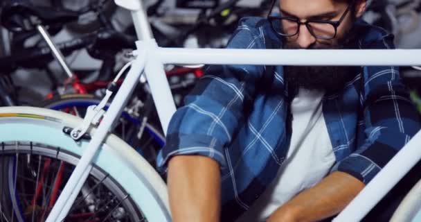 Mechanik naprawiający rower w warsztacie — Wideo stockowe