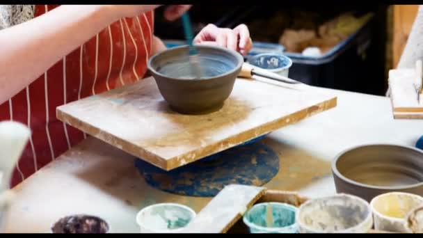 Vrouwelijke artiest schilderen op aardewerk bowl — Stockvideo