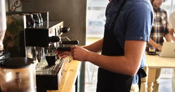 Servitören brygga kaffe medan par använder laptop — Stockvideo