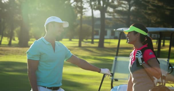 Pareja interactuando mientras juega al golf — Vídeo de stock