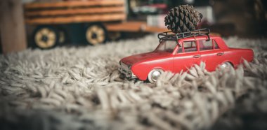 Toy car carrying christmas pine cone clipart