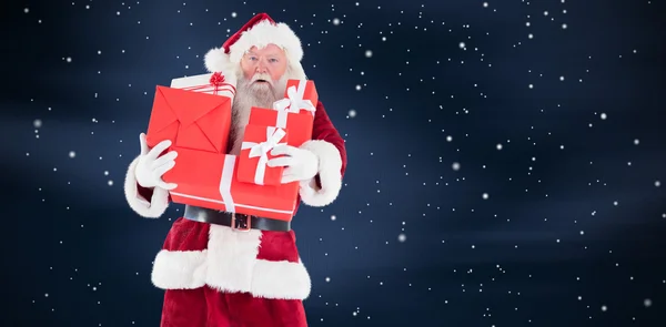 Santa draagt een paar presenteert — Stockfoto