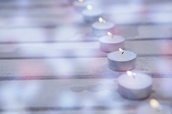 Candles burning on wooden plank — Stock Photo, Image