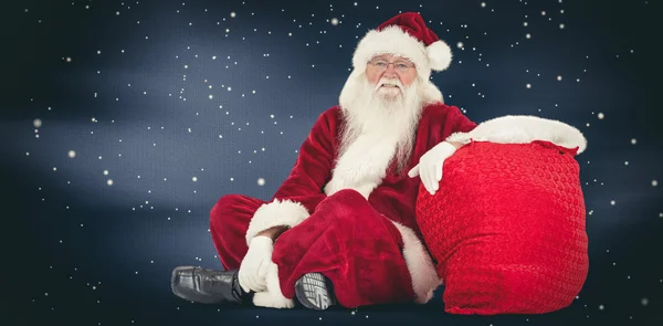 Santa zit naast zijn tas — Stockfoto