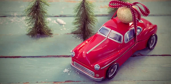 Toy car carrying christmas bauble ball — Stock Photo, Image