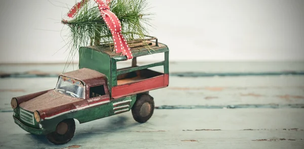 Tempo de brinquedo carregando abeto de natal — Fotografia de Stock