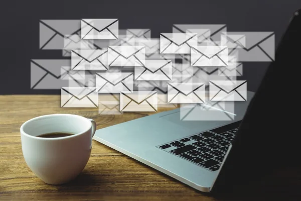 Laptop en koffie op een bureau met grafische letters — Stockfoto