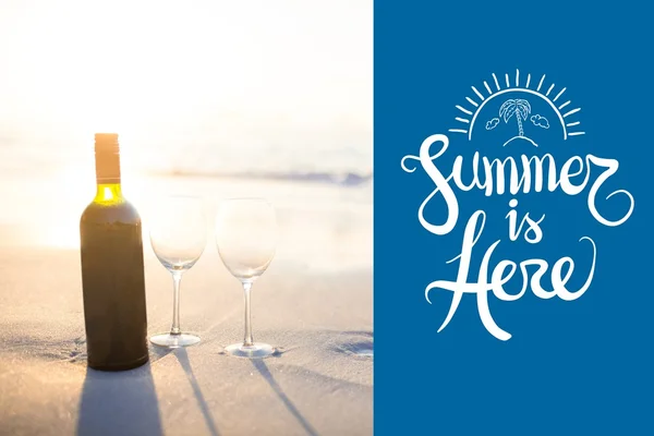 Verano está aquí y botella con vasos en la arena — Foto de Stock
