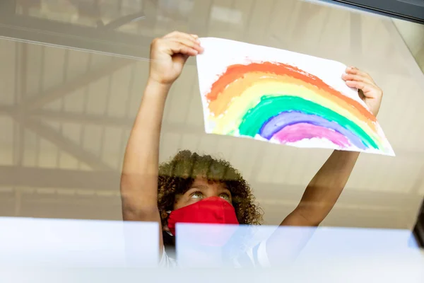 Schoolmeisje Draagt Gezichtsmasker Lijmt Een Regenboog Tekening Aan Een Raam — Stockfoto