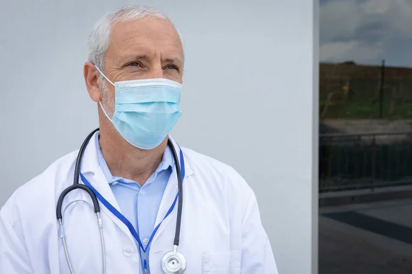 有自信的白人男性医学专业人员的画像 脖子上戴着听诊器 戴着面具看着相机 Coronavirus Covid 19大流行病期间工作场所的社会疏离和卫生 — 图库照片