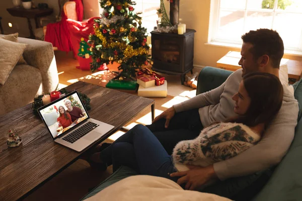 Pareja Sentada Sofá Teniendo Videocall Con Pareja Sombreros Santa Sonriendo — Foto de Stock