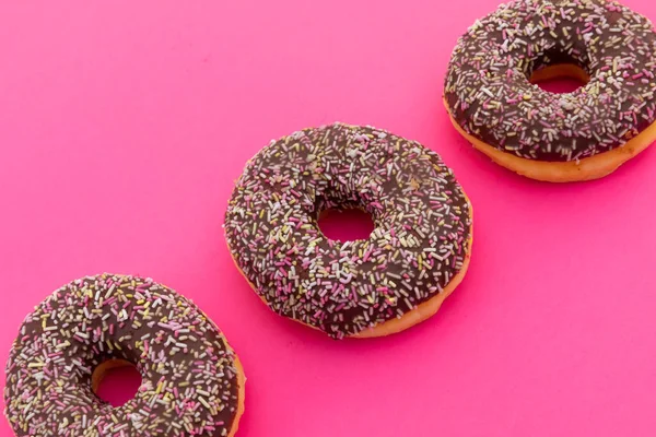 Vista Alto Ângulo Três Donuts Chocolate Com Polvilhas Sobre Fundo — Fotografia de Stock