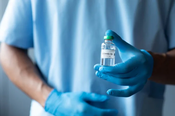 手袋を身に着けているCovid 19ワクチン接種を保持している男性医師の中央部 Covid 19コロナウイルスパンデミック時の医療専門家 — ストック写真