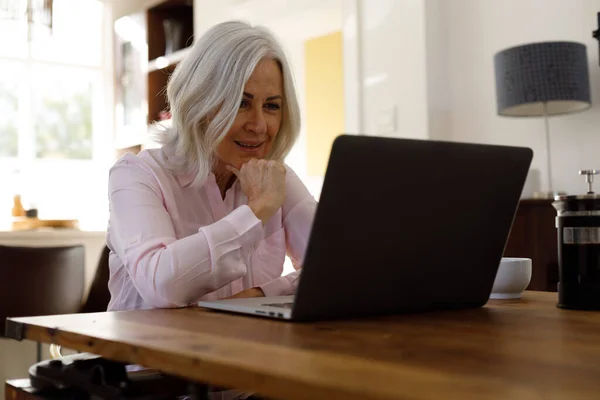 Üst Düzey Beyaz Kadın Evde Çalışırken Bilgisayarında Görüntülü Konuşma Yapıyor — Stok fotoğraf