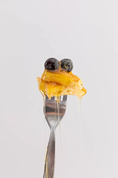 在白色背景的叉子上滴着蜂蜜的煎饼和浆果 食物甜点有趣的复制空间概念 — 图库照片