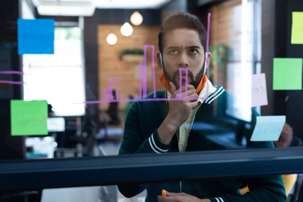 Mixed Race Man Wearing Face Mask Looking Information Glass Wall — Stockfoto