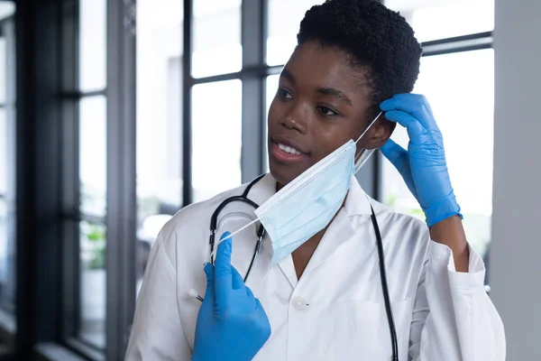 Mixed Race Female Doctor Standing Putting Face Mask Medical Professional — Stok fotoğraf