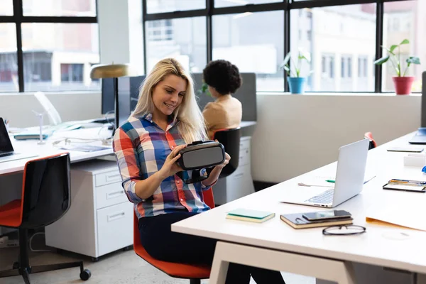 Caucasian Businesswoman Sitting Desk Holding Goggles Creative Office Colleague Background — Stok Foto