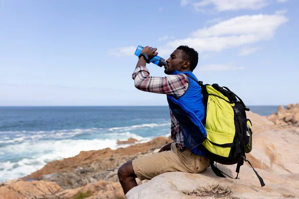 Fit African American Man Wearing Backpack Resting Drinking Water Coast — Stock fotografie