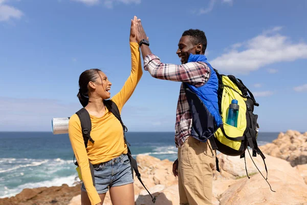 Fit African American Couple Wearing Backpacks High Fiving Hiking Coast — Stock fotografie