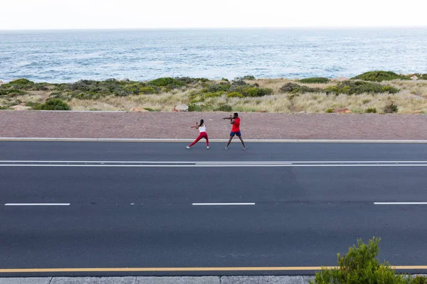 Ajuste Pareja Afroamericana Ropa Deportiva Que Extiende Una Carretera Costera —  Fotos de Stock