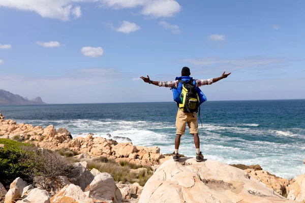 Fit African American Man Wearing Backpack Hiking Spreading Arms Coast — Stockfoto