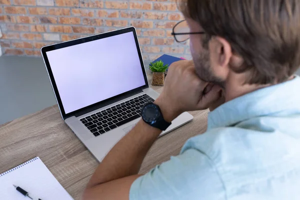 坐在办公桌前 用笔记本电脑进行视频通话的高加索人的背影 在封锁期间 在网上工作 与外界保持距离 — 图库照片