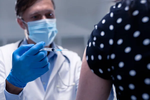 Καυκάσιος Άνδρας Γιατρός Φορώντας Μάσκα Προσώπου Και Γάντια Δίνοντας Εμβόλιο — Φωτογραφία Αρχείου