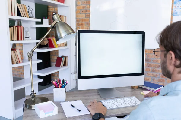 坐在办公桌前 用台式计算机进行视频通话的高加索人的背影 在封锁期间 在网上工作 与外界保持距离 — 图库照片