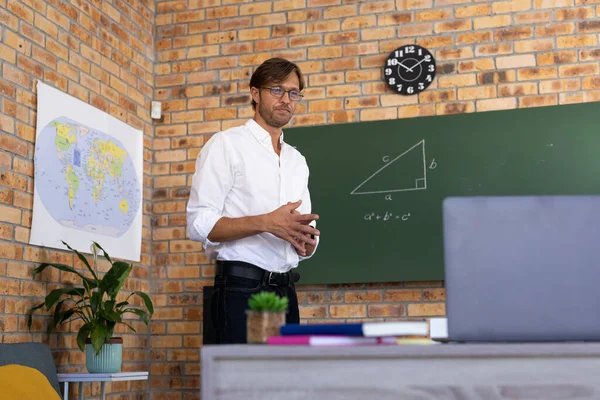 白人数学老师站在黑板旁 用笔记本电脑在网上授课 隔离期间的家庭教育及网上教育 — 图库照片