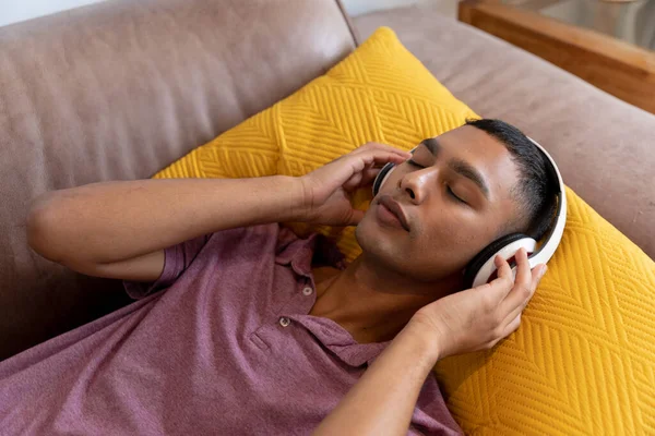 Smíšený Závodník Ležící Gauči Sluchátka Poslouchající Hudbu Pobyt Doma Izolaci — Stock fotografie