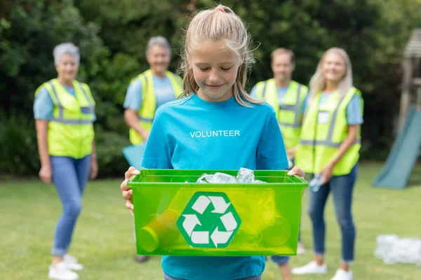 Kaukasisches Mädchen Mit Einer Recyclingbox Dahinter Eine Gruppe Männer Und — Stockfoto