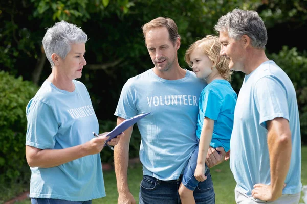 Caucasian Senior Couple Clipboard Father Carrying Son Volunteer Shirts Talking — Stock Photo, Image