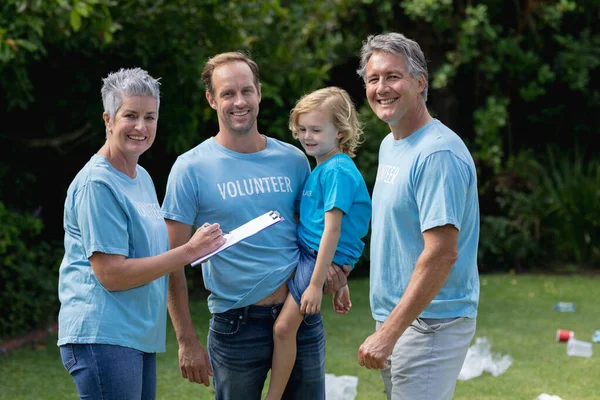 Caucasian Senior Couple Father Son Volunteer Shirts Smiling Littered Field — Stock Photo, Image