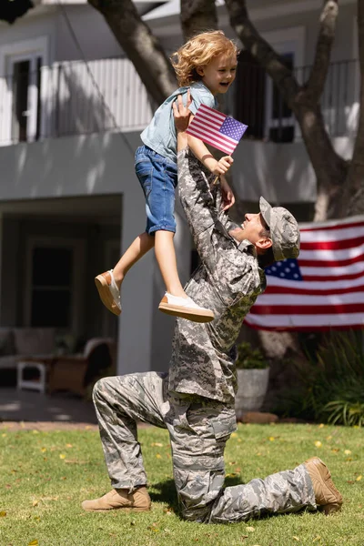 Sonriente Soldado Caucásico Padre Levantando Feliz Hijo Jardín Con Bandera — Foto de Stock