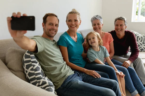 白人の父親は妻 息子とソファに座って 笑顔で自撮りをしていました 幸せな3世代の家族が家で一緒に過ごす時間 — ストック写真