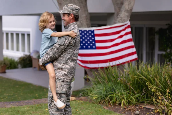 Vit Soldat Far Bär Son Trädgården Med Amerikansk Flagga Hängande — Stockfoto