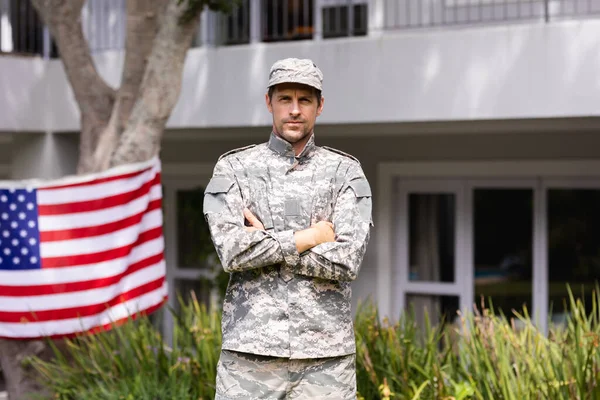 アメリカ国旗が家の外に飾られた庭に立つ白人男性兵士の肖像画 兵士は家族の元に戻り — ストック写真