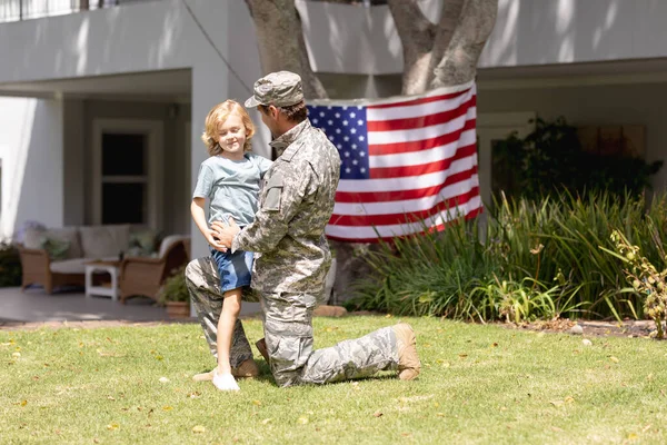 Caucasian Soldier Father Kneeling Embracing Son Garden American Flag Hanging — Stock Photo, Image