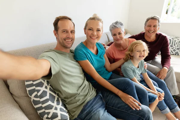 白种人的父亲坐在沙发上 和他的妻子 父母和儿子笑着自私自利 快乐的三代家庭一起呆在家里 — 图库照片