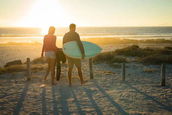 Coppia Caucasica Sulla Spiaggia Che Trasporta Tavola Surf Durante Tramonto — Foto Stock